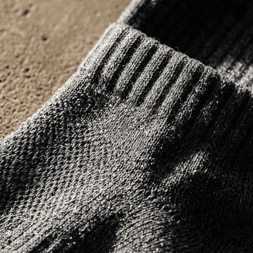 Macro of damp heather grey crew sock knit — wet fiber after a long shift, bacterial odor context